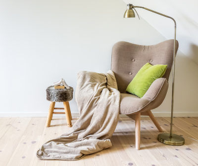 Reading chair with lamp and blanket on hard wood floor